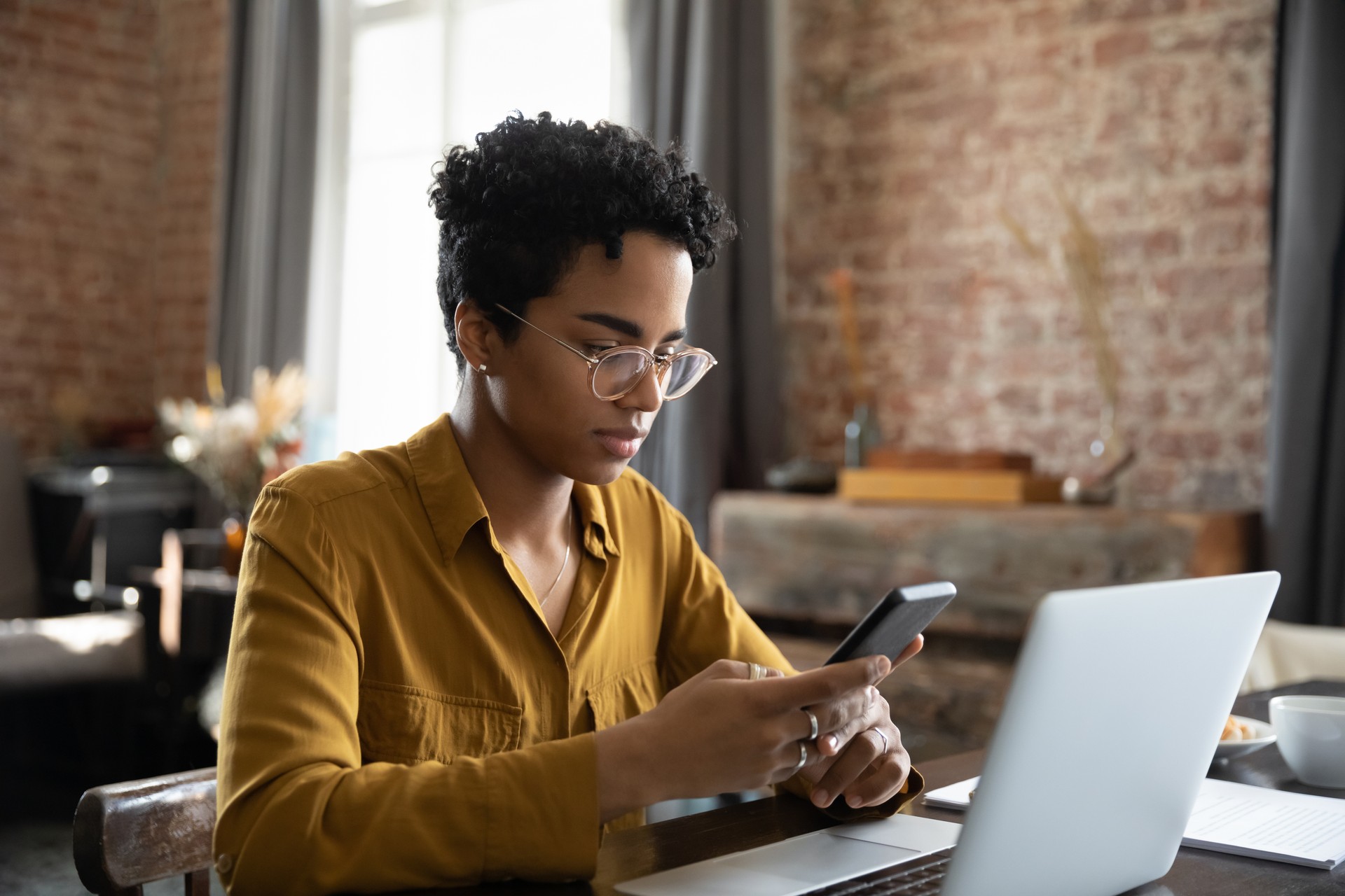 African woman synchronize files between laptop and smartphone use application